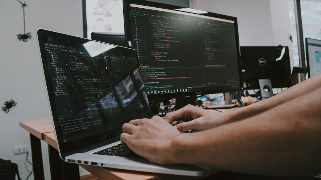 programmer typing code on laptop