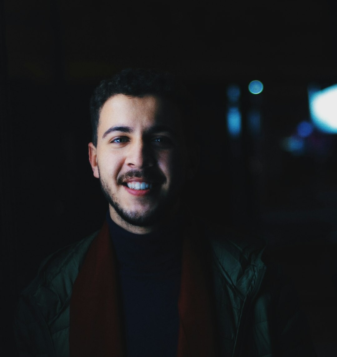Studio portrait of a man with a beard smiling at the camera